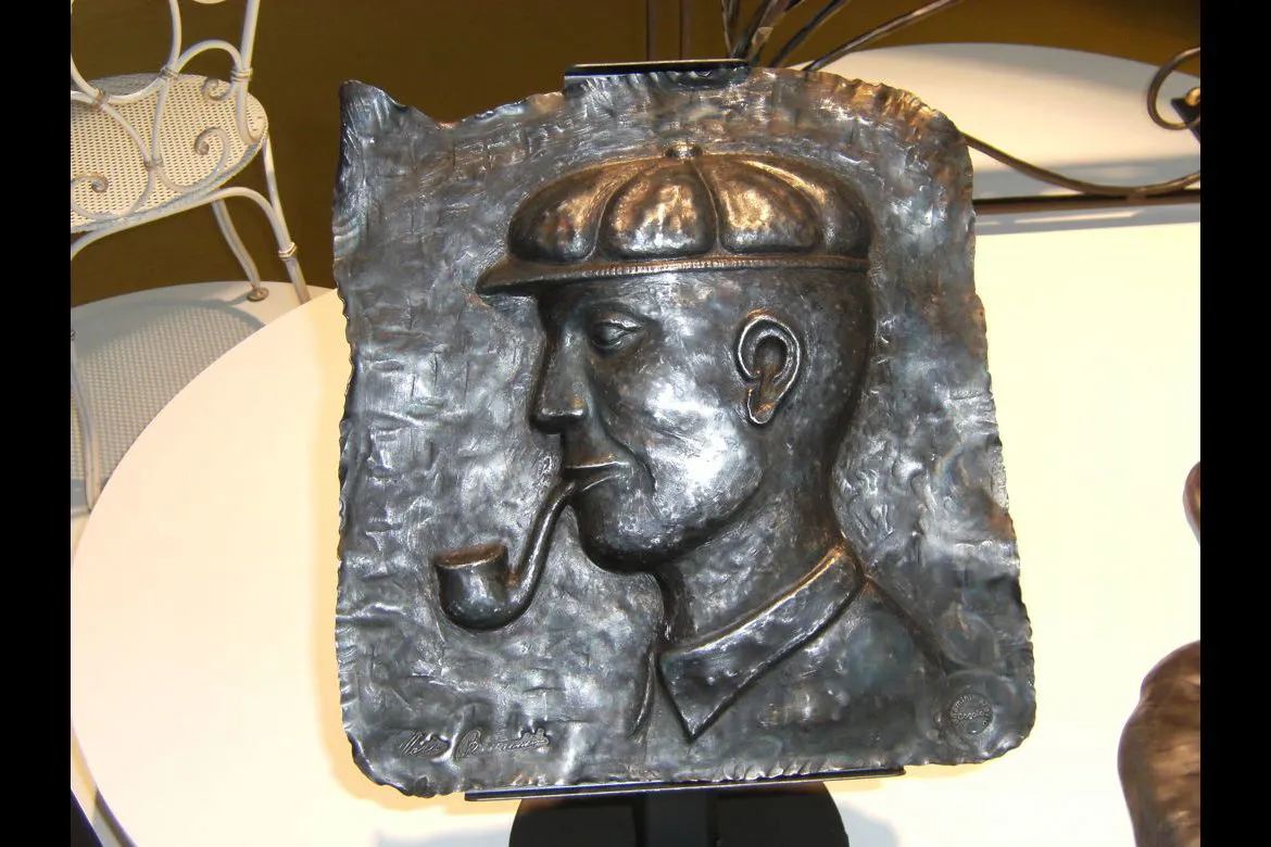 Scultura in ferro battuto il vecchio con la pipa.